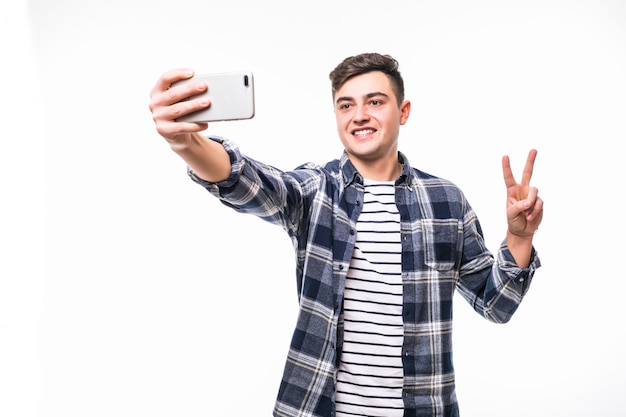 Cheerful teenager taking funny selfies with his mobile phone