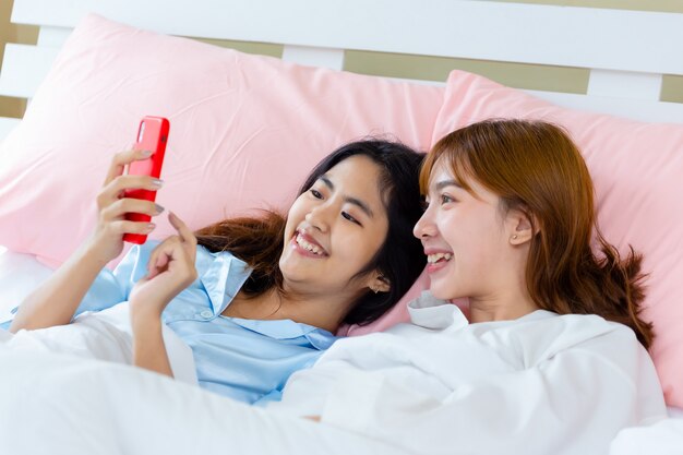 Cheerful teenager woman use smartphone selfie on bed