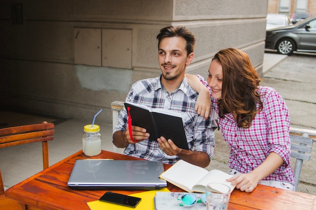 Cheerful teens watching book together