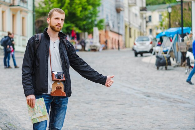 Cheerful tourist man hitchhiking