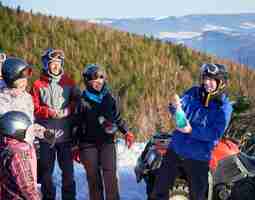 Free photo cheerful travelers drinking champagne in mountains