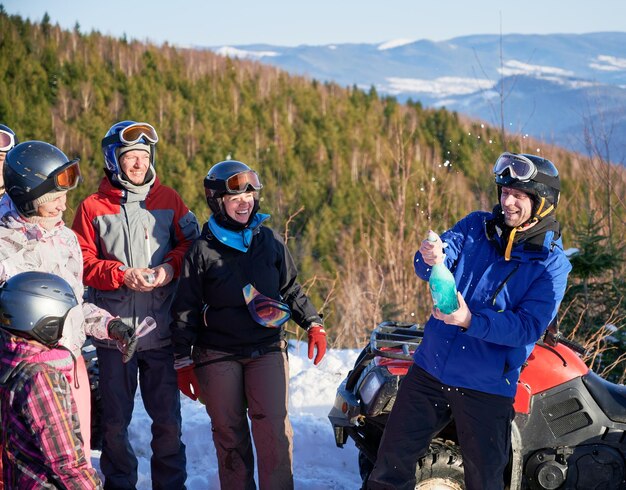 Cheerful travelers drinking champagne in mountains