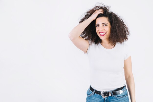 Cheerful woman adjusting hair