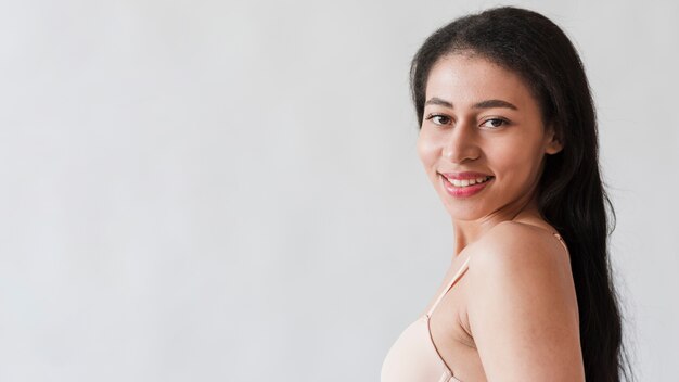 Cheerful woman in bra looking at camera