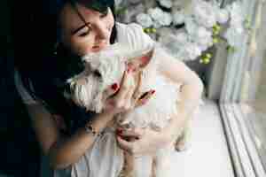 Free photo cheerful woman cuddling with dog