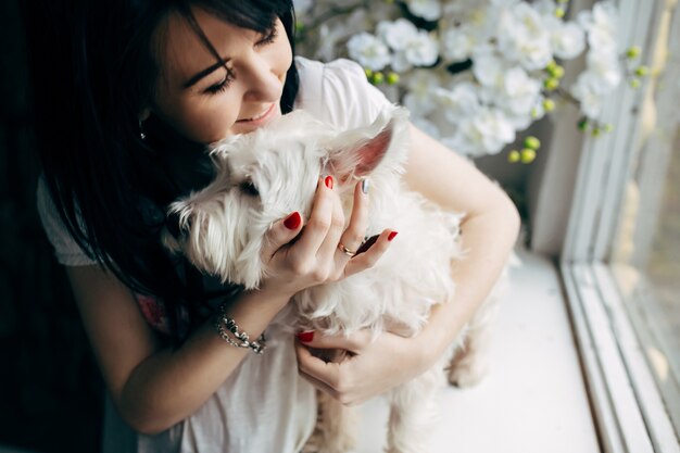 犬と抱き合っている陽気な女性