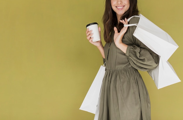 コーヒーとショッピングネットのドレスで陽気な女性