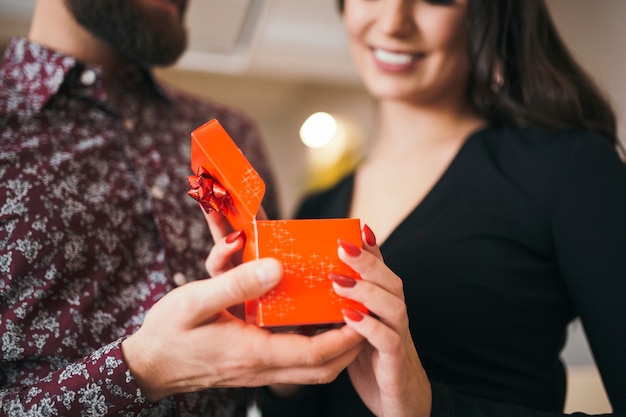 Cheerful woman getting present from man