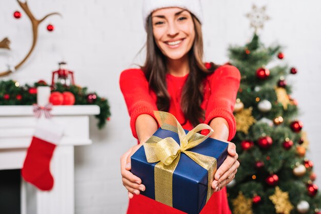 Cheerful woman giving present box