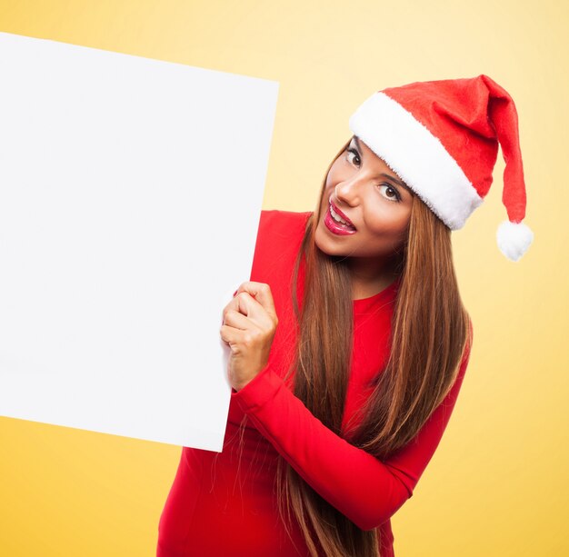 Cheerful woman holding an empty placard on yellow background