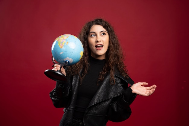 Free photo cheerful woman holding globe.