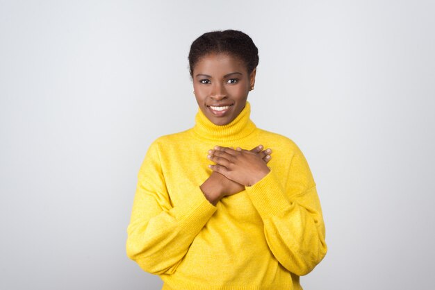 Cheerful woman holding hands on chest