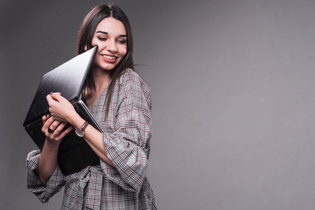 Cheerful woman hugging laptop