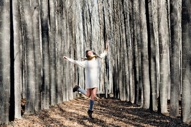 Free photo cheerful woman jumping and laughing in the forest