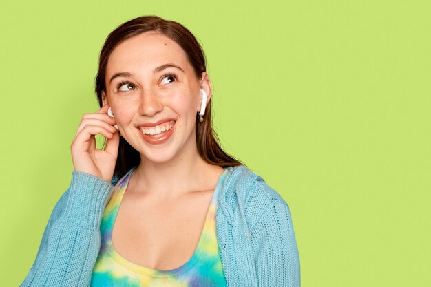 Cheerful woman listening to music through earphones