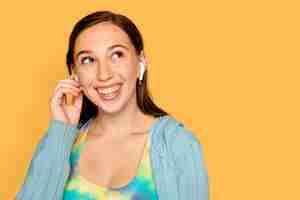 Free photo cheerful woman listening to music through earphones