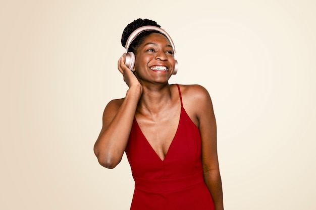 Cheerful woman listening to music through headphones digital device