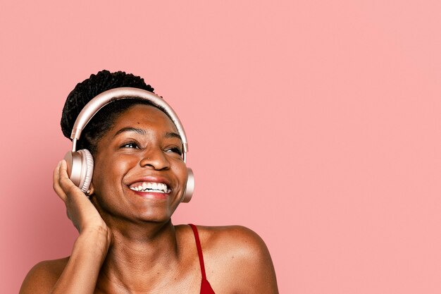 Cheerful woman listening to music through headphones digital device