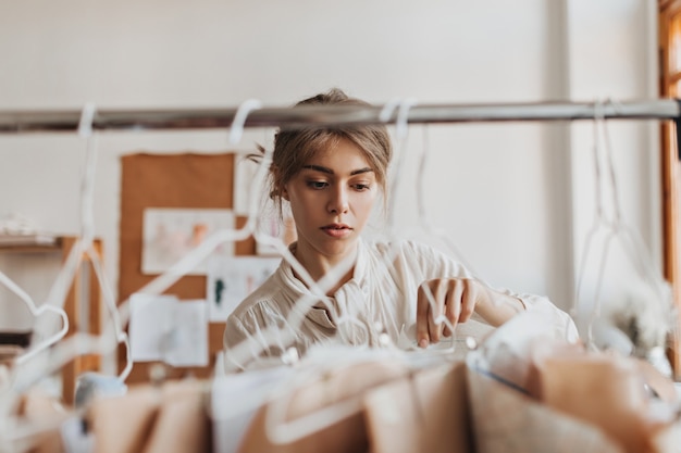 Cheerful woman looks at her clothing samples