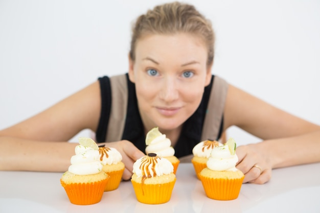 Free photo cheerful woman offering to taste cupcake