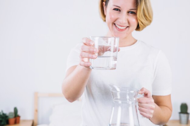 Cheerful woman offering water