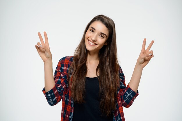 Cheerful woman in plaid shirt make peace gesture