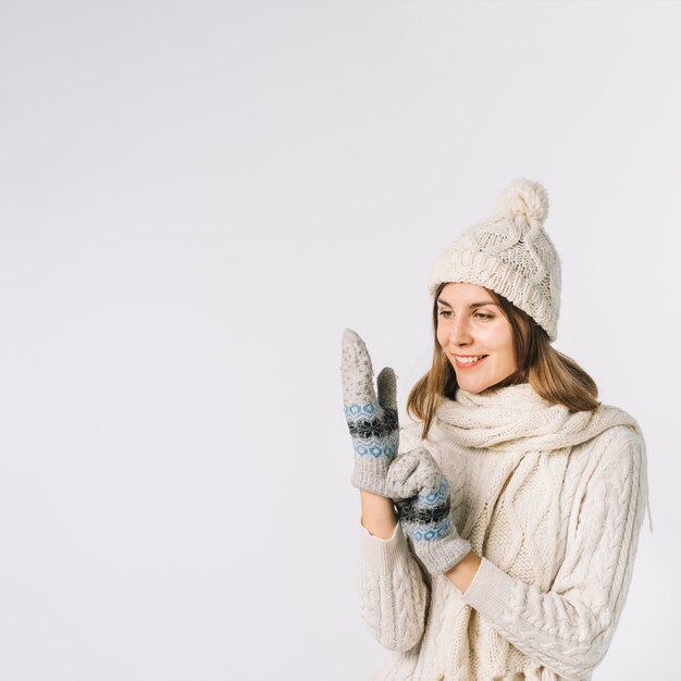 Cheerful woman putting on mittens