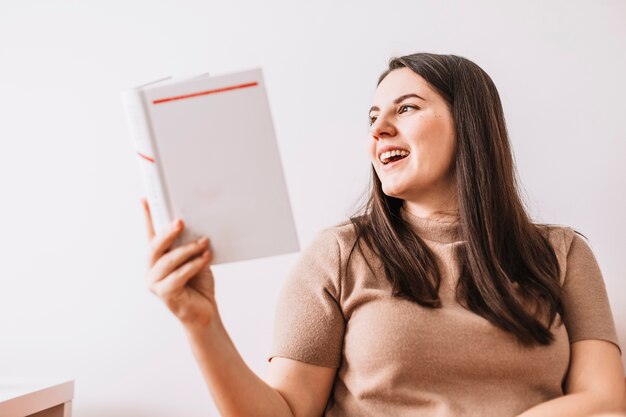 Cheerful woman reading book