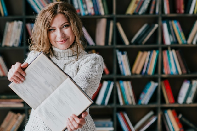 Cheerful woman shooing opened book