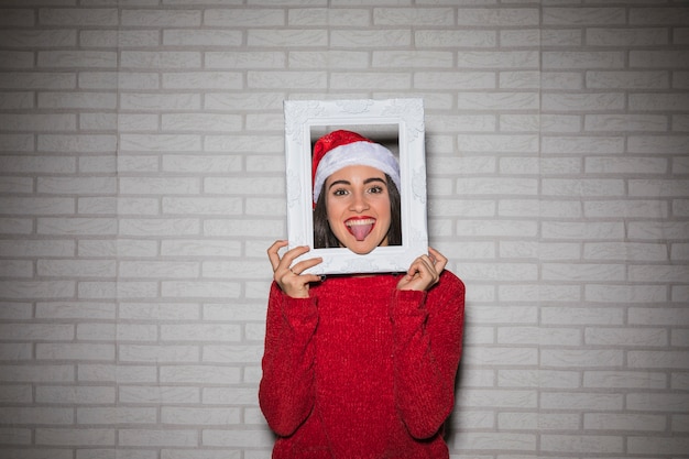 Free photo cheerful woman showing tongue out in frame