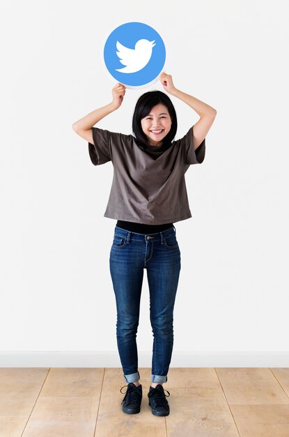 Cheerful woman showing a Twitter icon