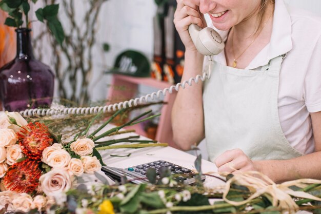 Cheerful woman speaking on phone in shop