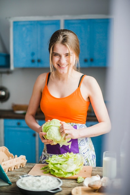 Cheerful woman stripping cabbage