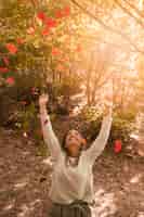 Free photo cheerful woman throwing autumn leaves