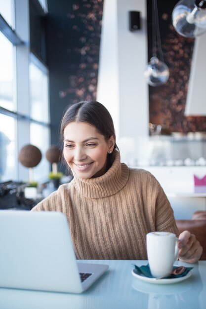 Coworking 공간에서 노트북을 사용하는 쾌활한 여자