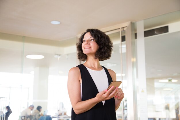 Cheerful woman waiting someone in hotel lobby