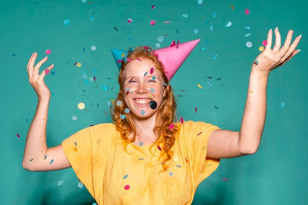 Cheerful woman wearing two birthday cones