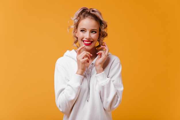 Cheerful woman with beautiful smile, insidiously looks away