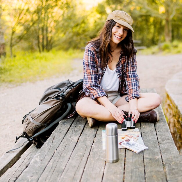 Cheerful woman with binoculars on table