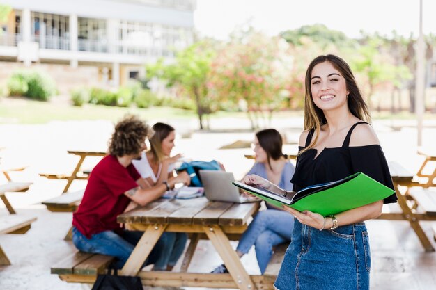 Cheerful woman with book looking at camera