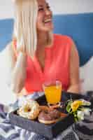 Foto gratuita donna allegra con prima colazione sul letto