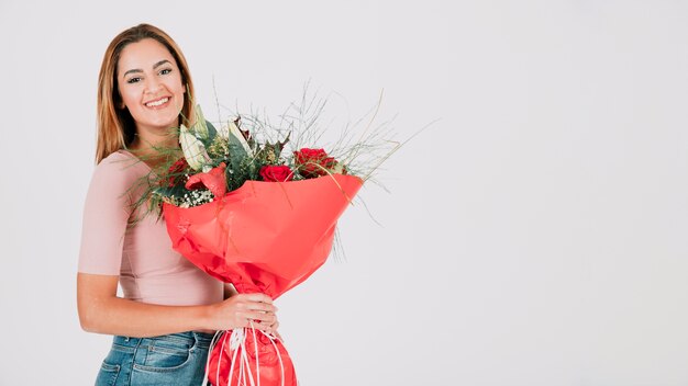 Cheerful woman with bunch of roses