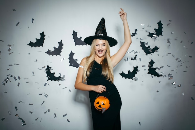 Cheerful woman with confetti and pumpkin