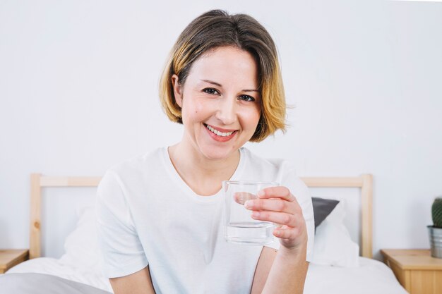 水のガラスで陽気な女性