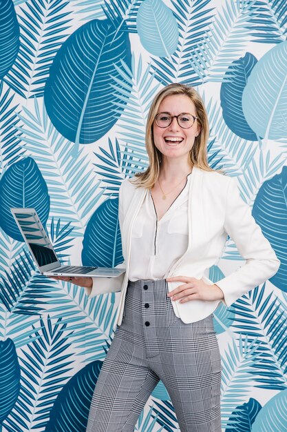 Cheerful woman with laptop in office
