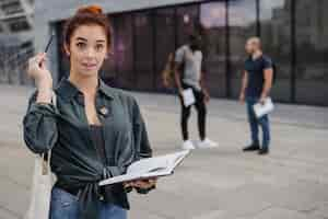 Free photo cheerful woman with pencil and book