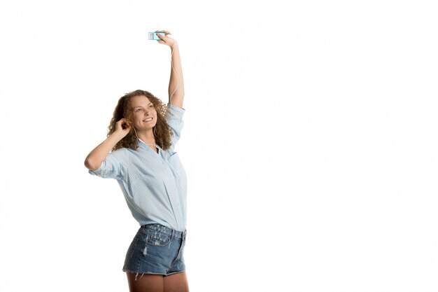 Cheerful woman with a raised hand listening to music