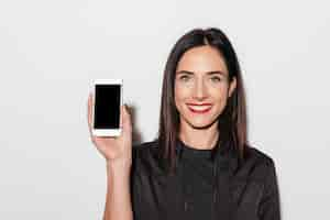 Free photo cheerful woman with red lips showing display of mobile phone.