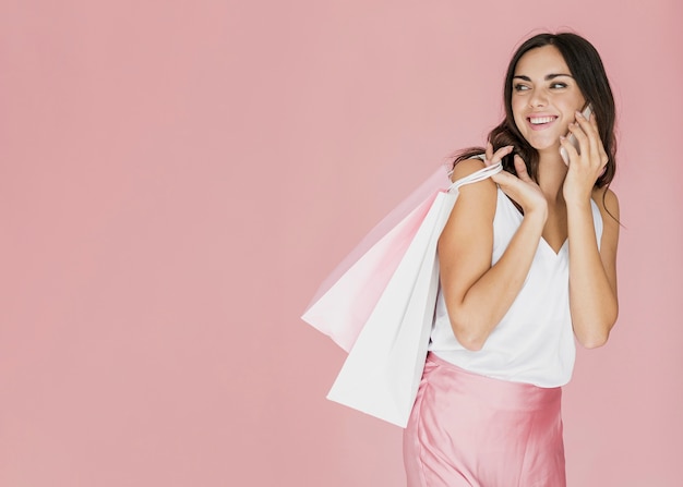 Cheerful woman with shopping bags looking back