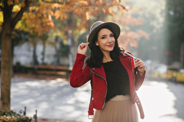 晴れた9月の日にポーズをとる短い黒髪の陽気な女性